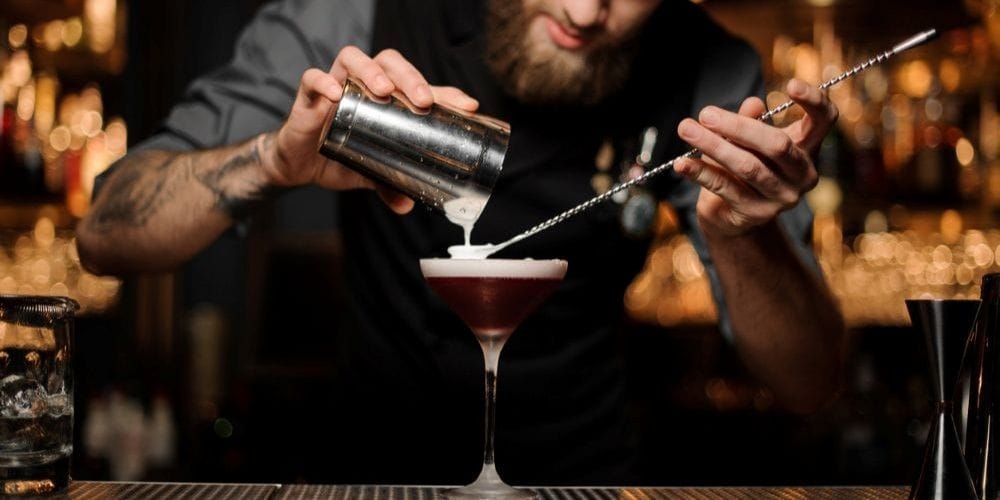 Bartender creating a cocktail drink.