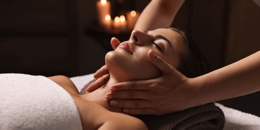 Massage therapist giving a face massage.