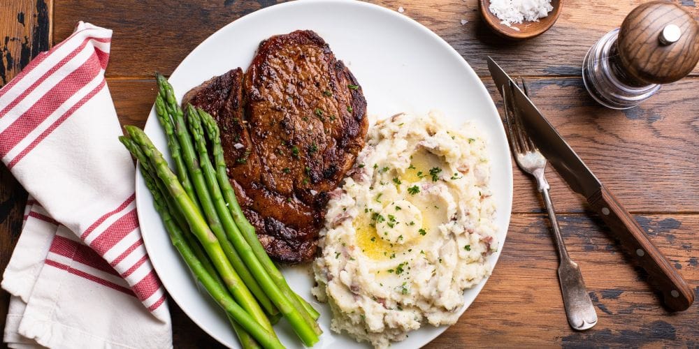 Steak dinner with mashed potatoes and asparagus.