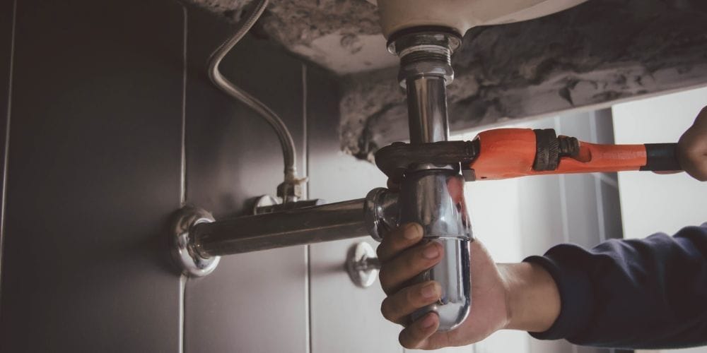 Plumber fixing leaky pipe.
